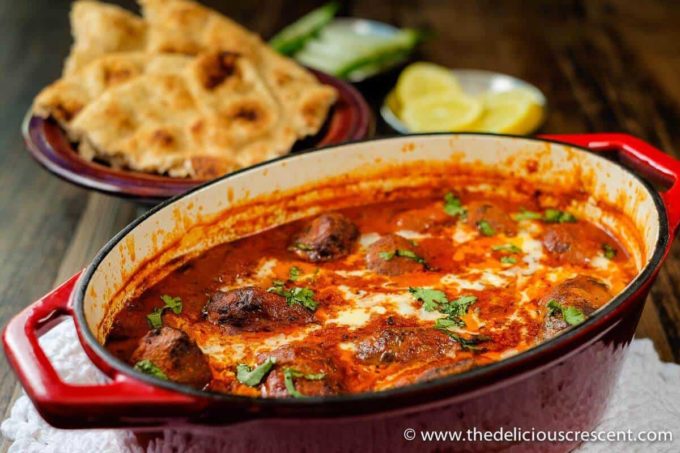 Kofta curry is a delicious dish of succulent grilled or broiled beef meatballs in a rich, creamy and spicy sauce. It is full of fragrant Indian spices and makes a great weeknight dinner. This easy low carb meatball curry recipe is also freezer friendly. Great tips for lightening up the sauce included. Make it with ground lamb or gluten free. #Indianfood #kofta #curry #beef Close up view of kofta curry served in a cast iron dish.