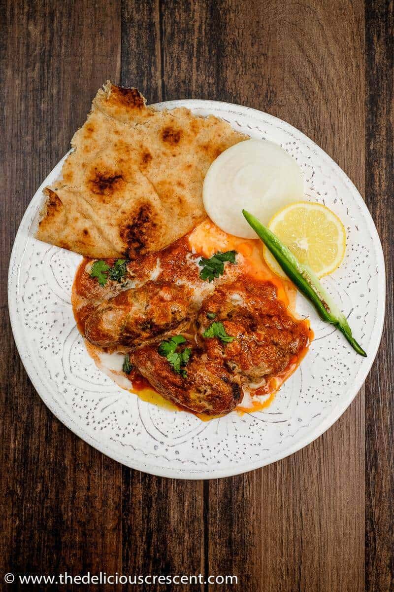 Meatball curry served with flatbread, onion, lemon and green chili.