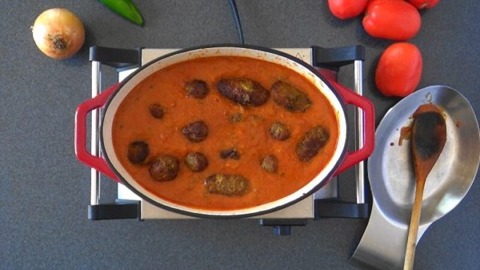 Broiled koftas added to seasoned tomato based gravy.