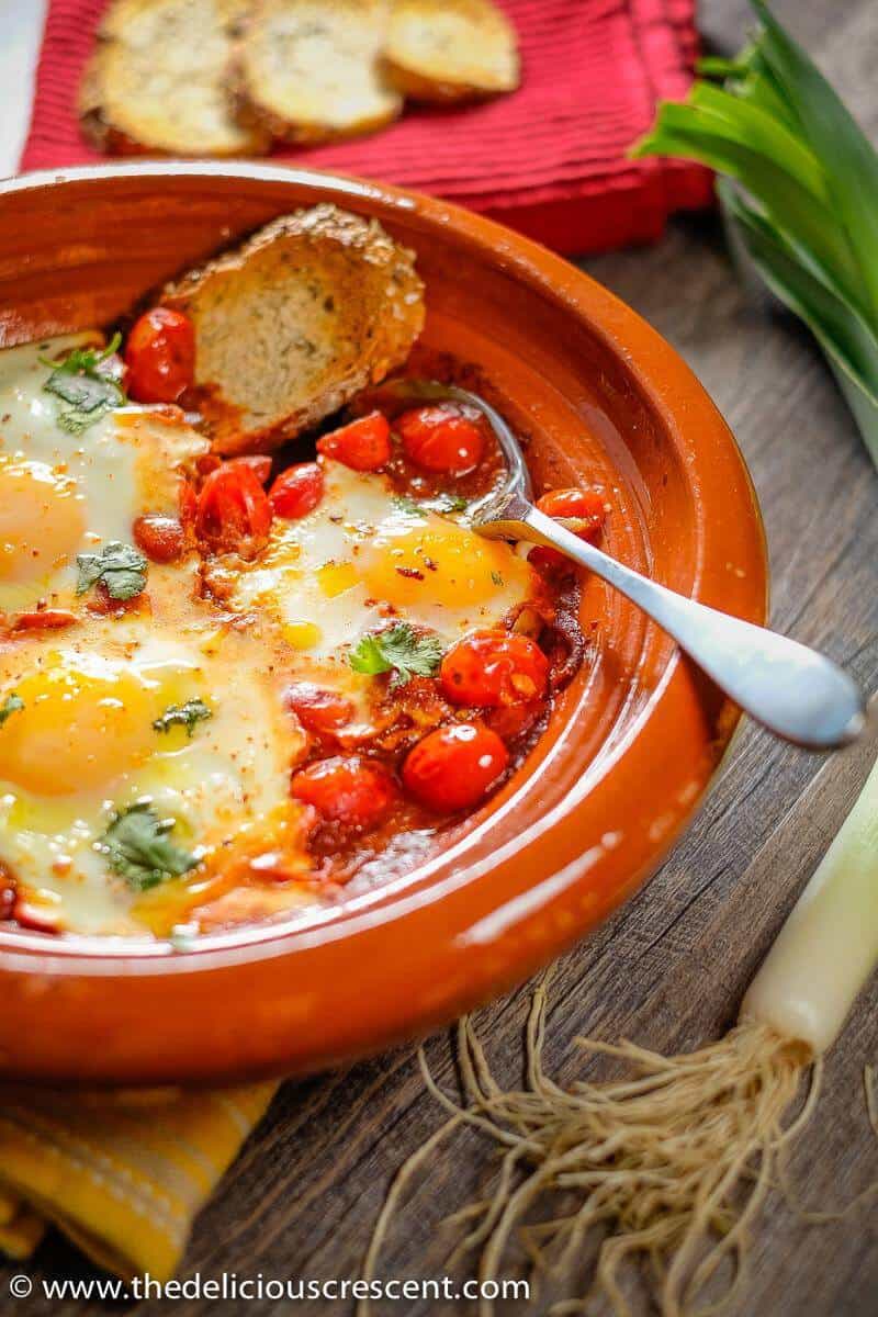 Moroccan eggs in tomato sauce cooked in a Tagine.