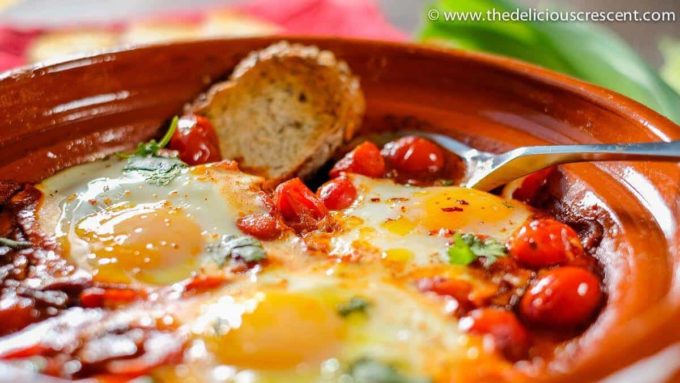 A close up photo of Moroccan eggs in tomato sauce, a healthy comfort dish.