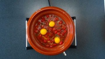 Moroccan Eggs in Tomato Sauce. Eggs are cracked and added to the tomato sauce.