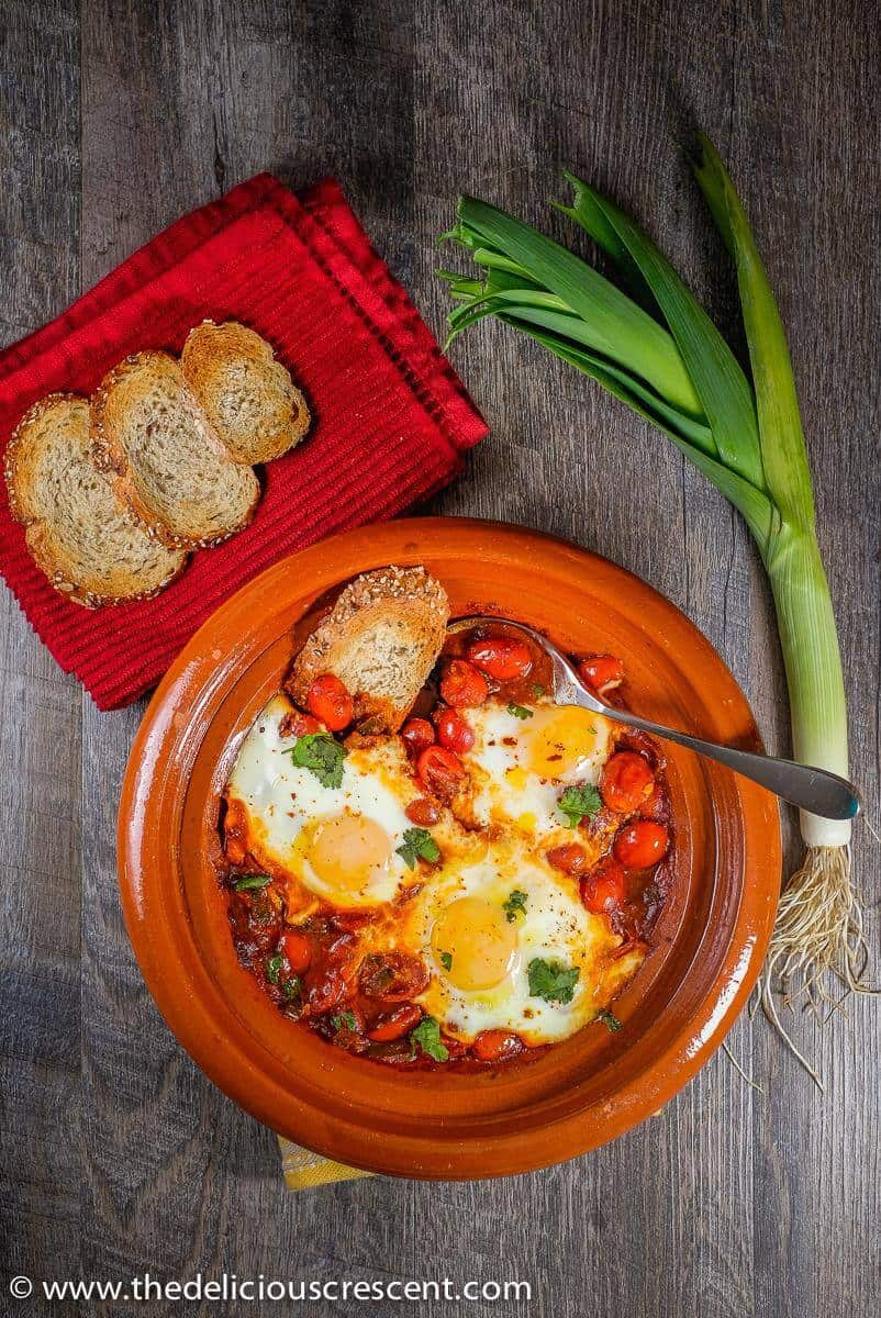 Moroccan eggs in tomato sauce, a healthy comfort dish, served with some toasted bread. 