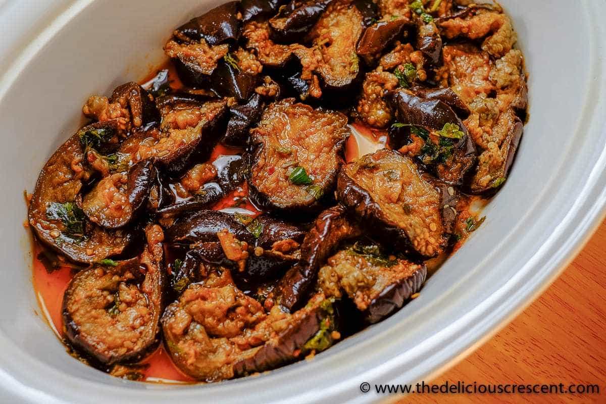 Close up view of Moroccan eggplant salad smothered in chermoula and served in a white dish.