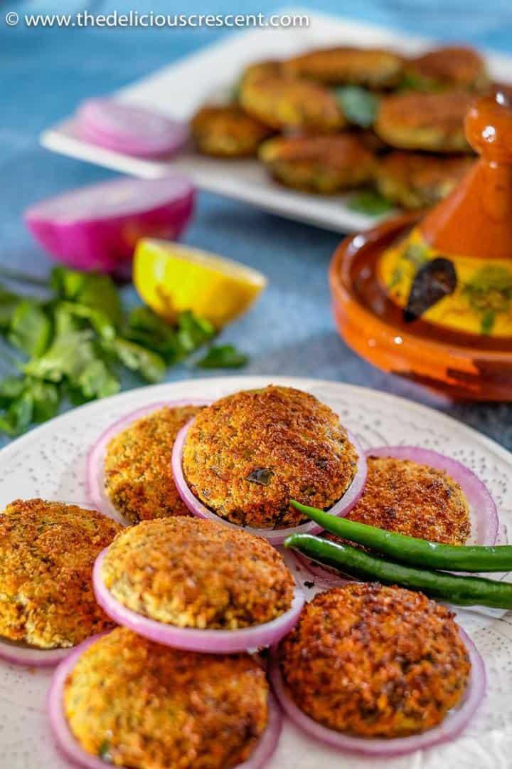 Broiled meat patties with potatoes, served with onion slices, lemon and chilies.