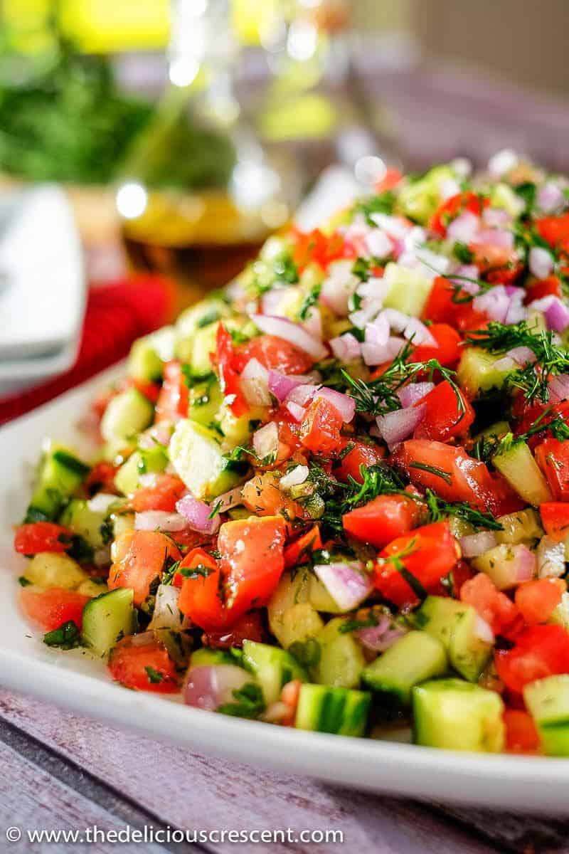 Close up view of Persian tomato cucumber salad with fresh herbs.
