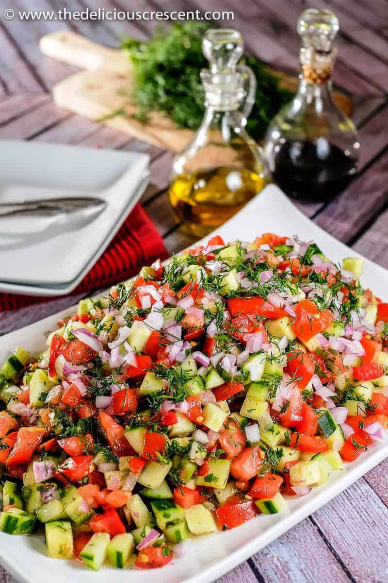 Salad Shirazi, a Persian tomato cucumber salad piled on a plate and placed on the table.