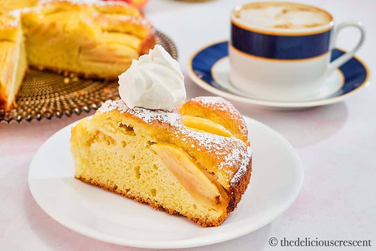 A cake wedge with whipped cream on the top.