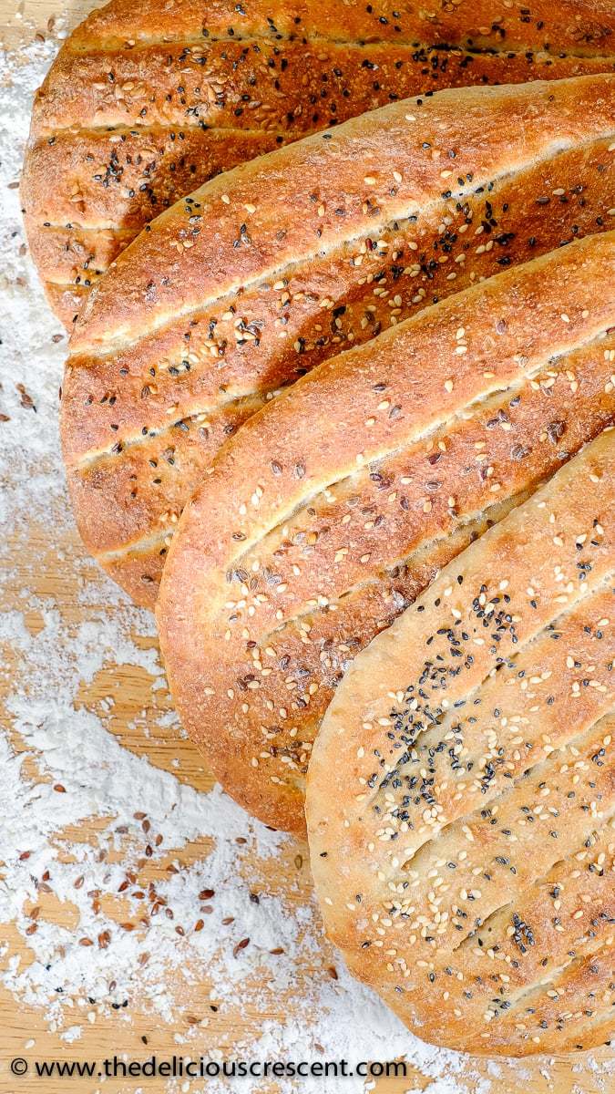 Barbari Bread is a classic Persian flatbread that is a must try for those who love baking bread. Crusty outside, tender inside and super tasty! Also known as Nan-e Barbari or Noon Barbari, this is a popular breakfast bread in Iran. It is freezer friendly and vegan. The recipe also includes tips for making it healthier. #breadrecipe #Persian #middleeasternfood A few barbari breads arranged together.