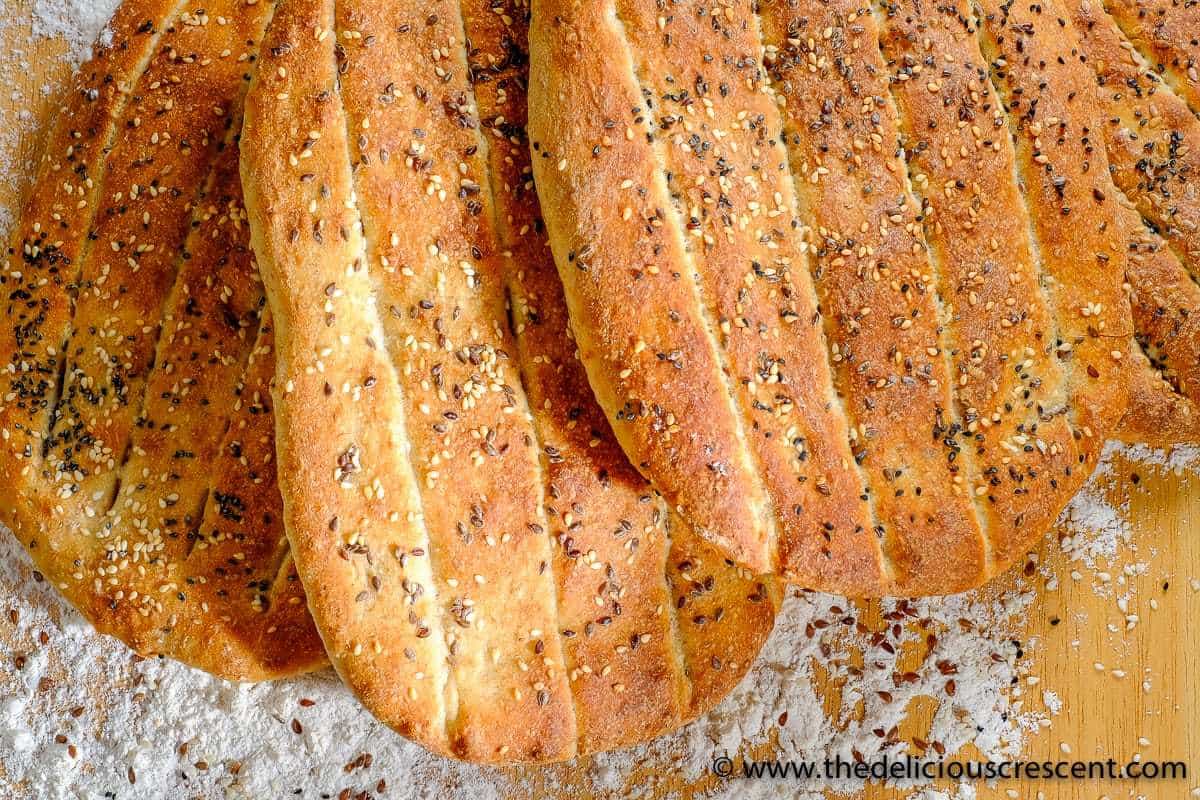 Few barbari flat bread loaves arranged on a table.