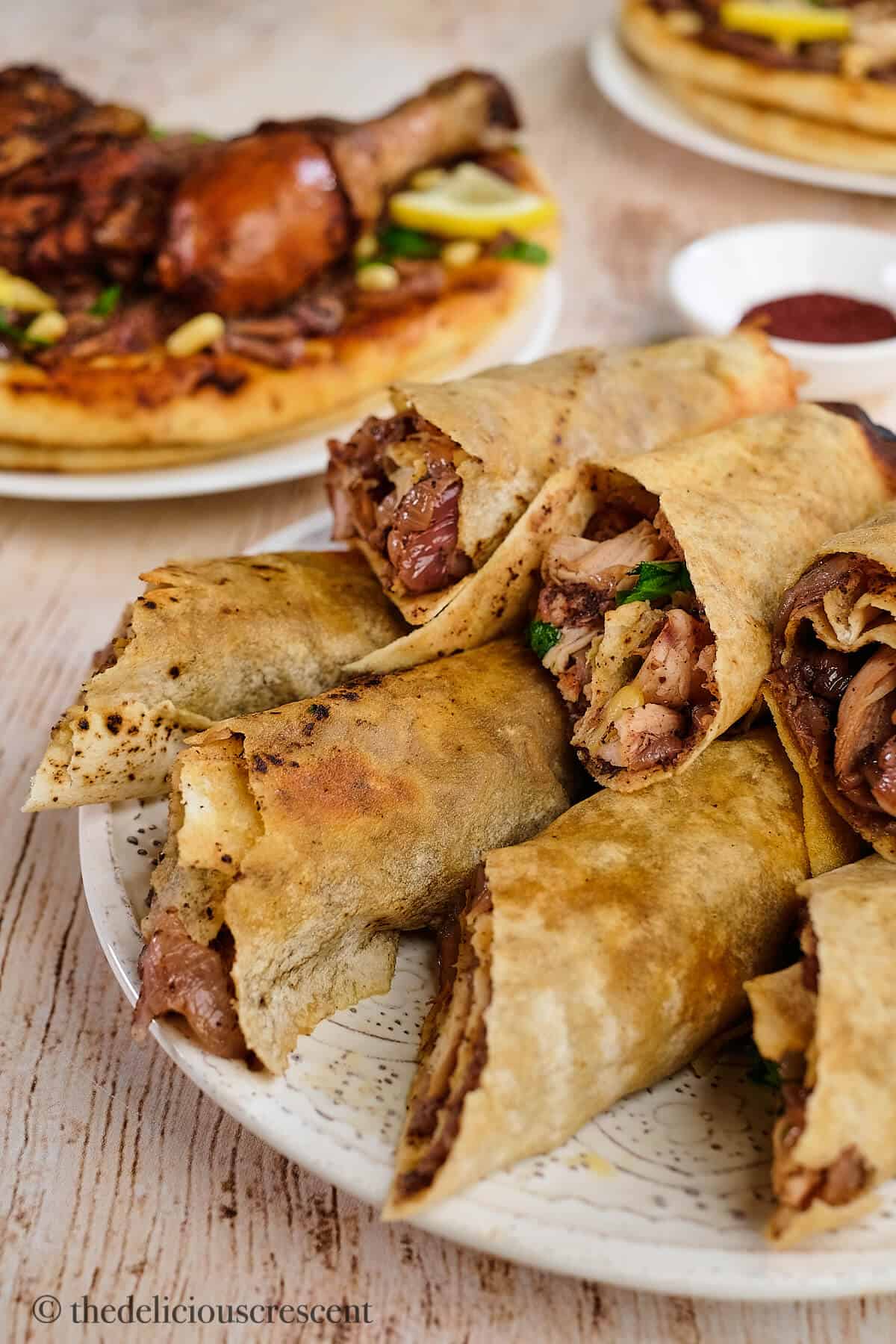 Palestinian musakhan rolls served in a white plate.