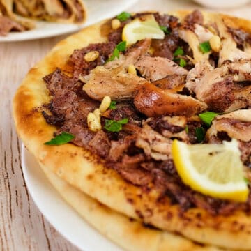 Close view of Palestinian sumac chicken onion flatbread served on the table.