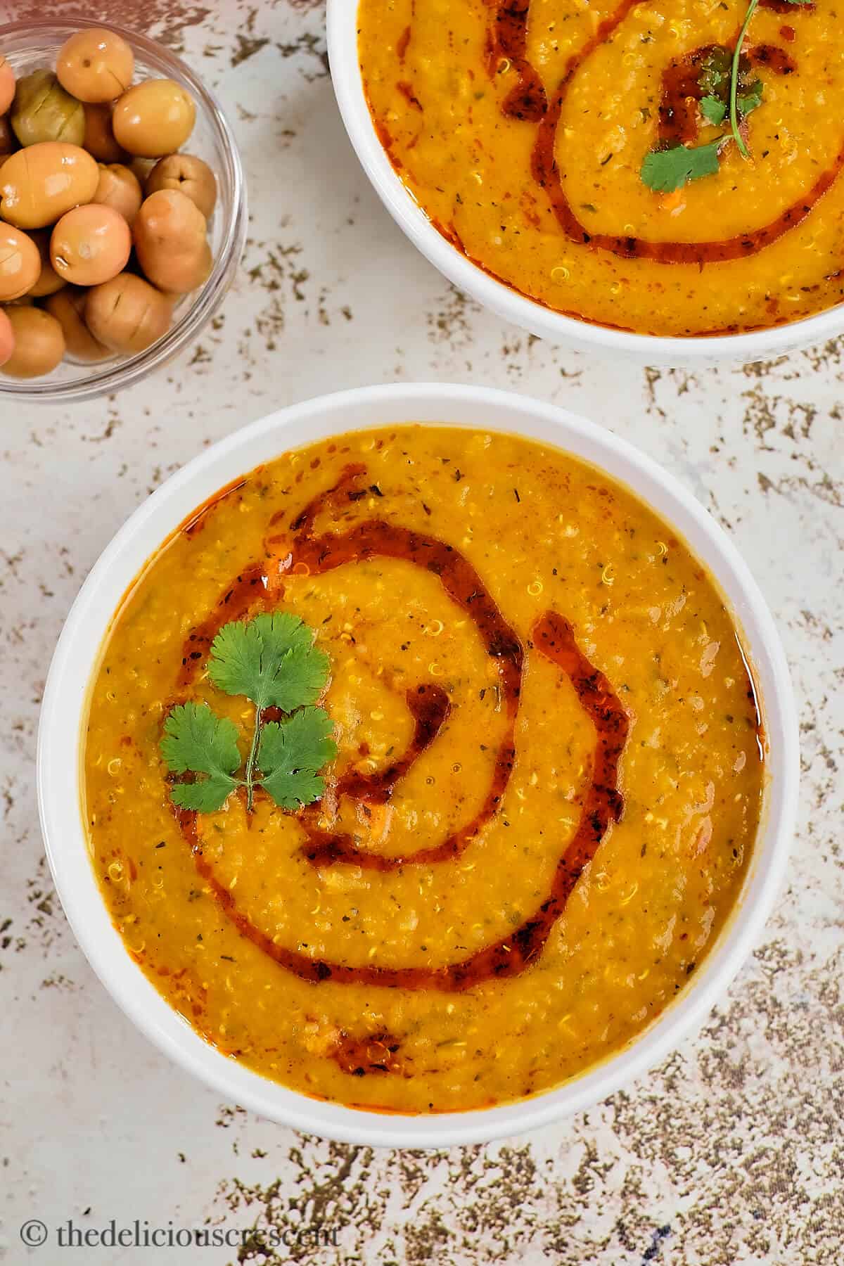 Turkish red lentil soup served in white bowls on the table.