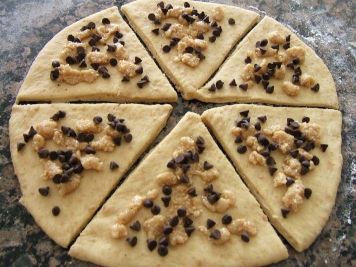 Rolled out dough cut into triangles and topped with chocolate and hazelnuts.