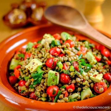 Spicy lentil salad with avocado in a serving dish.