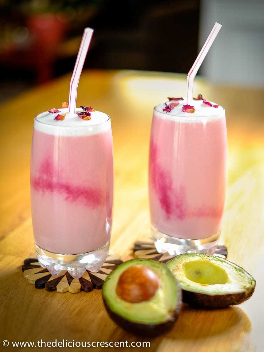 Healthy rose milk made with avocados and milk served in two glasses.