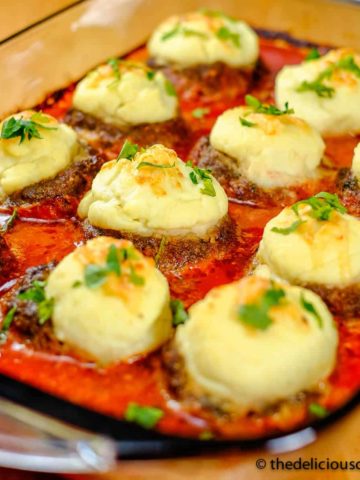 Stuffed meatballs in tomato sauce (pashas kofta) in a serving dish.