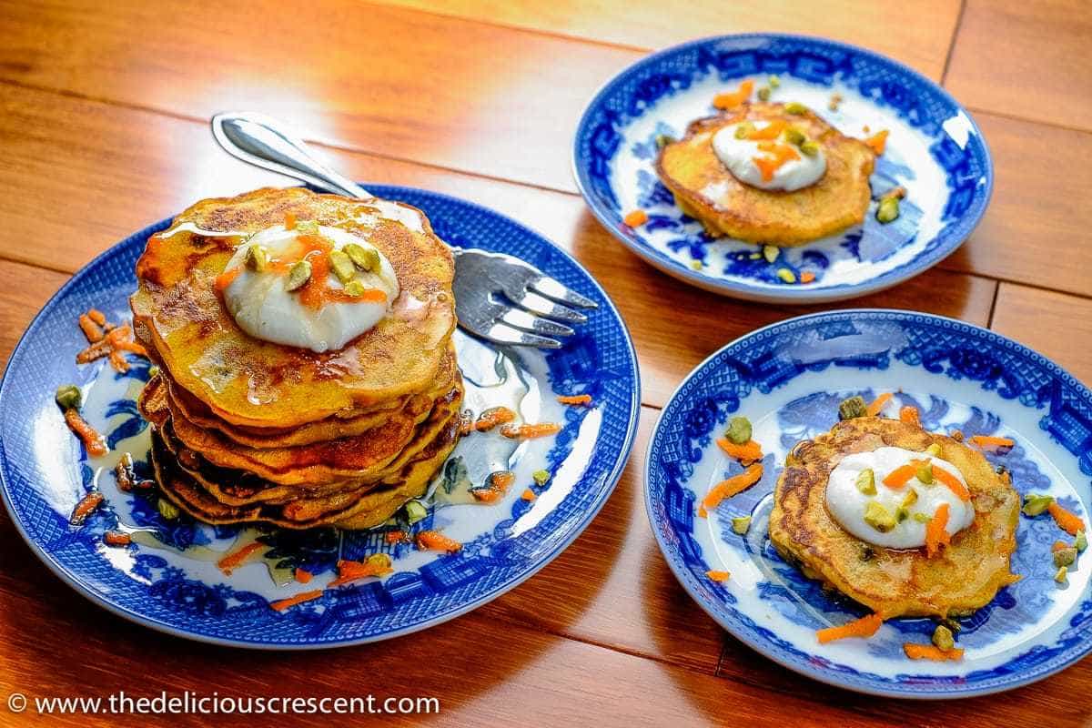 Dessert pancakes made with carrots served on three plates.