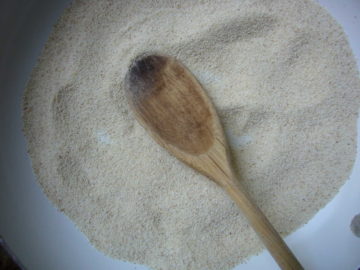 Semolina being roasted in a skillet.