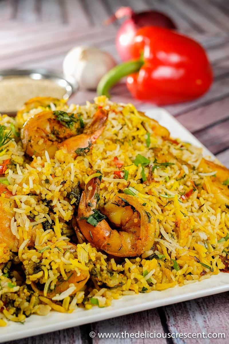 Persian style shrimp and rice served on a white plate and placed on a table.