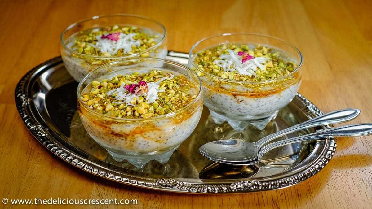 Bowls of Chia Mahalabia with Pistachios placed on a tray