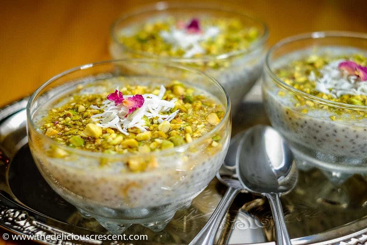 Chia mahalabia with pistachios is an Arabic style rice pudding with chia seeds added into the recipe that is fragrant with rose water. This is a creamy gluten free pudding that is healthy, easy and a quick dessert. Check out this unique chia pudding loaded with good taste, nutrition and learn about the health benefits too. #chiapudding #ricepudding. Chia Mahalabia with Pistachios served in bowls