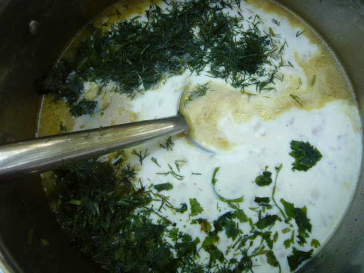Fresh herbs being added to the chickpea yogurt soup.