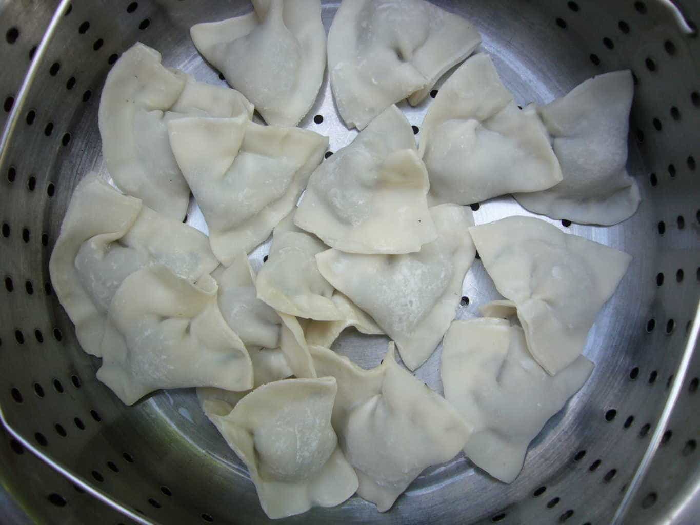 Manti dumplings with mushroom filling placed in a steamer basket.