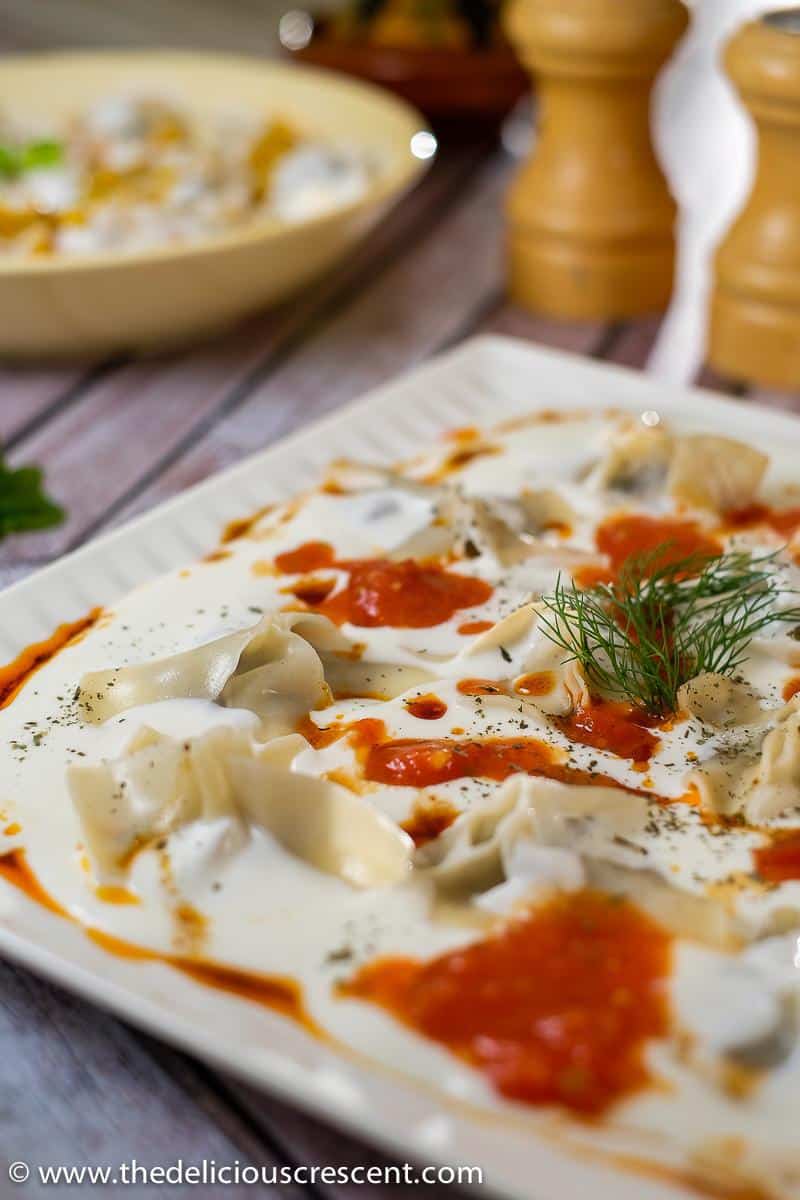 Manti dumplings with mushroom filling covered with garlic yogurt sauce, paprika butter and mint.