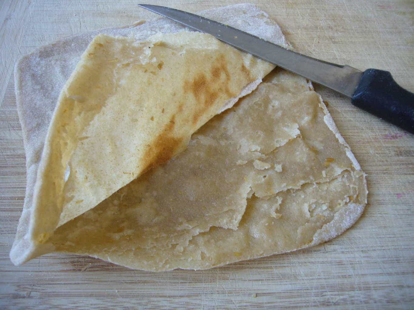 Opening the half cooked paratha layers for making egg paratha.