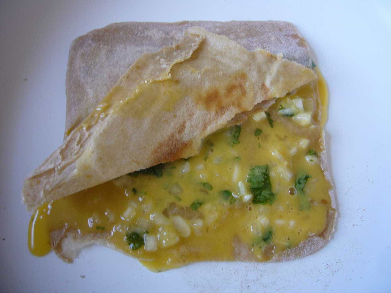 Stuffing with egg mixture inside the layered flat bread to make egg paratha.