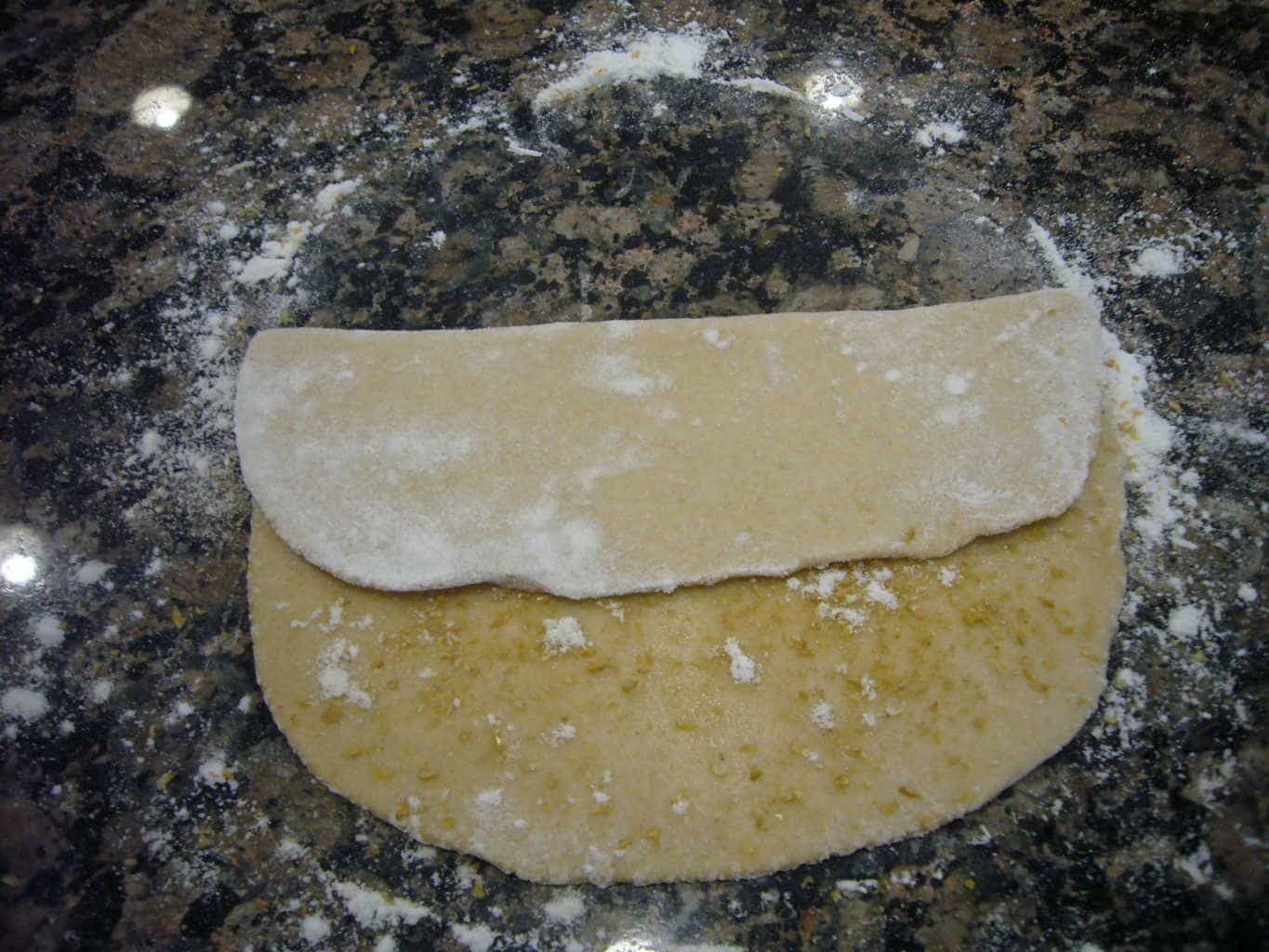 The rolled out dough is folded on one side.
