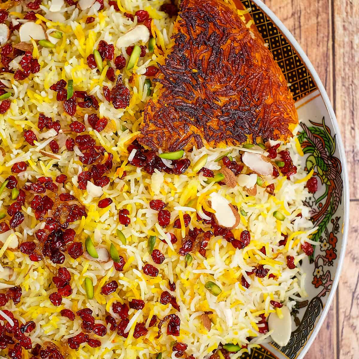 Close view of zereshk polo with tahdig in a plate.