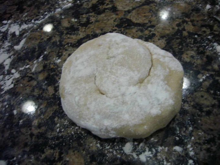 Stuffed paratha dough portion dusted with flour.
