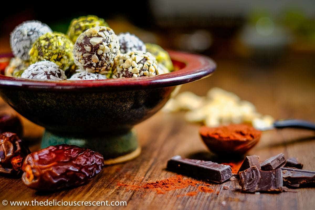 Dark chocolate date avocado truffles are a melt-in-your-mouth treat. These easy, healthy, low carb, gluten free homemade truffles are made without heavy cream or butter. They are sweetened with dates and have minimal added sugar and saturated fat. A great chocolate dessert snack for holidays! Vegan and dairy free options. #truffles #healthysnacks #chocolaterecipes Side angle picture of avocado chocolate truffles