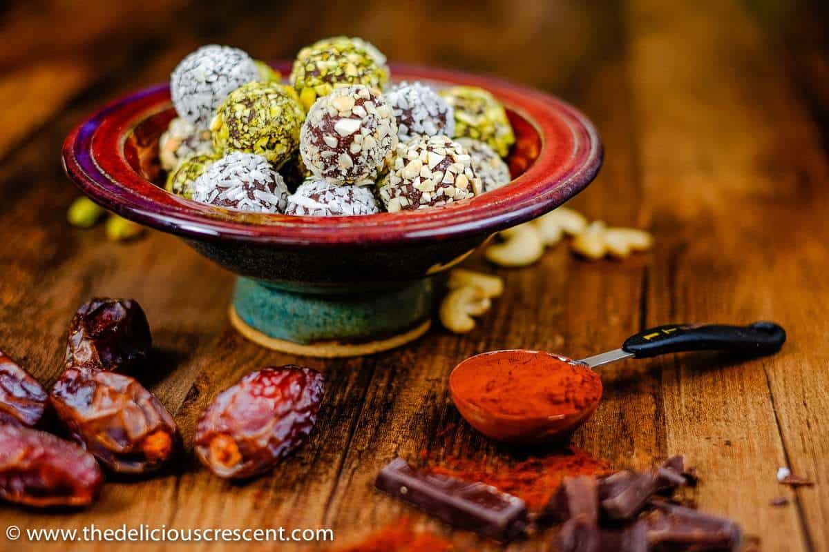 Dark chocolate date avocado truffles are a melt-in-your-mouth treat. These easy, healthy, low carb, gluten free homemade truffles are made without heavy cream or butter. They are sweetened with dates and have minimal added sugar and saturated fat. A great chocolate dessert snack for holidays! Vegan and dairy free options. #truffles #healthysnacks #chocolaterecipes Avocado chocolate truffles with the ingredients around