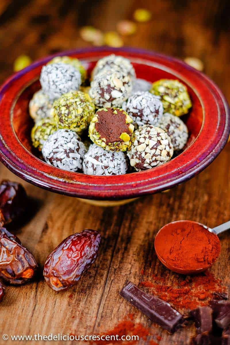 Dark chocolate date avocado truffles are a melt-in-your-mouth treat. These easy, healthy, low carb, gluten free homemade truffles are made without heavy cream or butter. They are sweetened with dates and have minimal added sugar and saturated fat. A great chocolate dessert snack for holidays! Vegan and dairy free options. #truffles #healthysnacks #chocolaterecipes Close up picture of avocado chocolate truffles