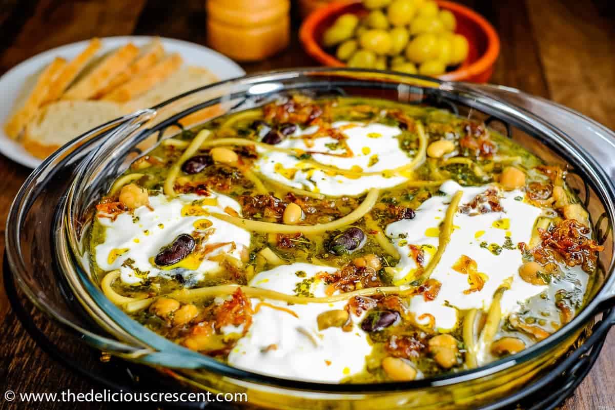 Ash-e reshteh served on the table with olives.