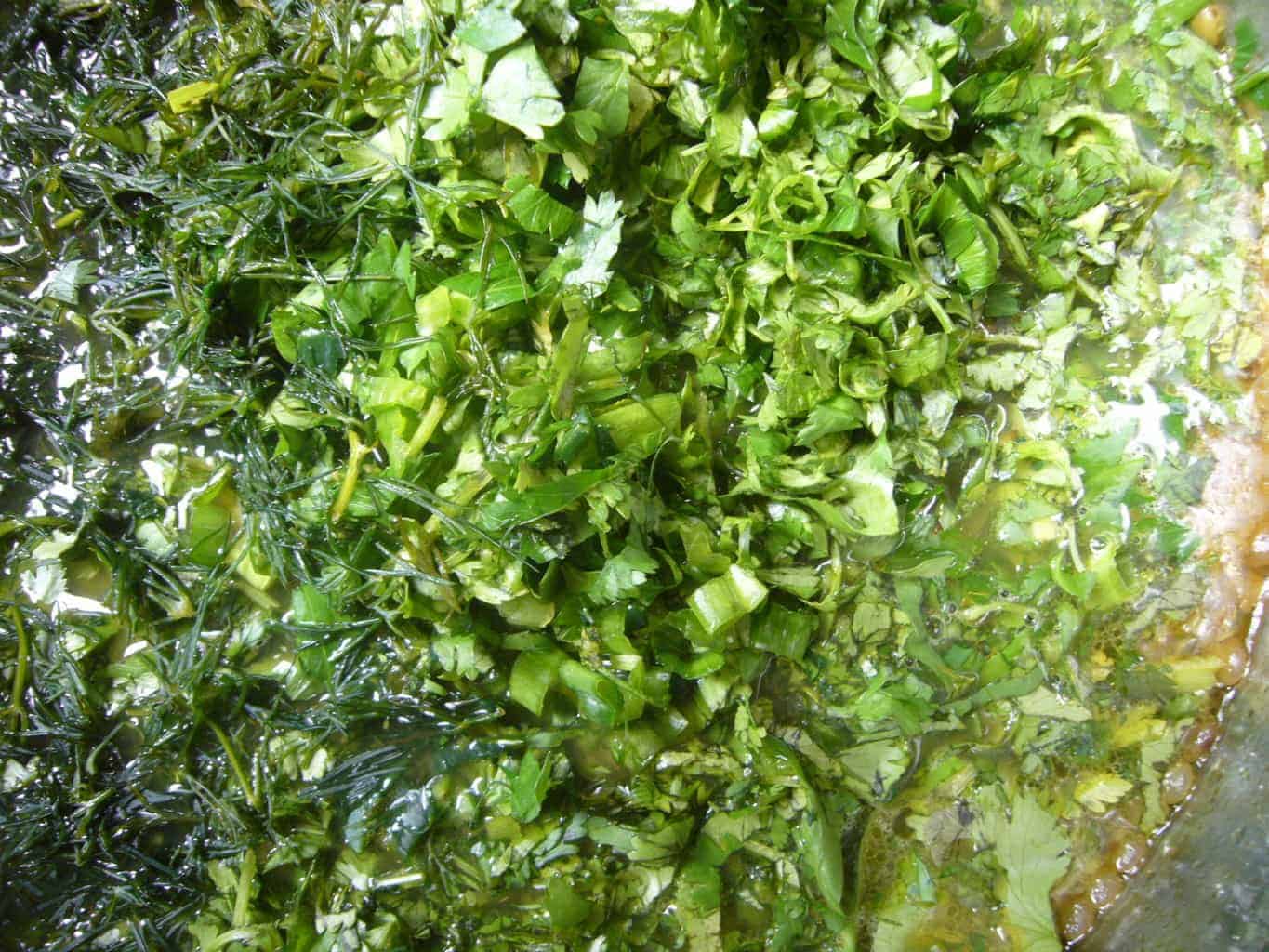 Fresh greens and herbs added to make Persian noodle soup.