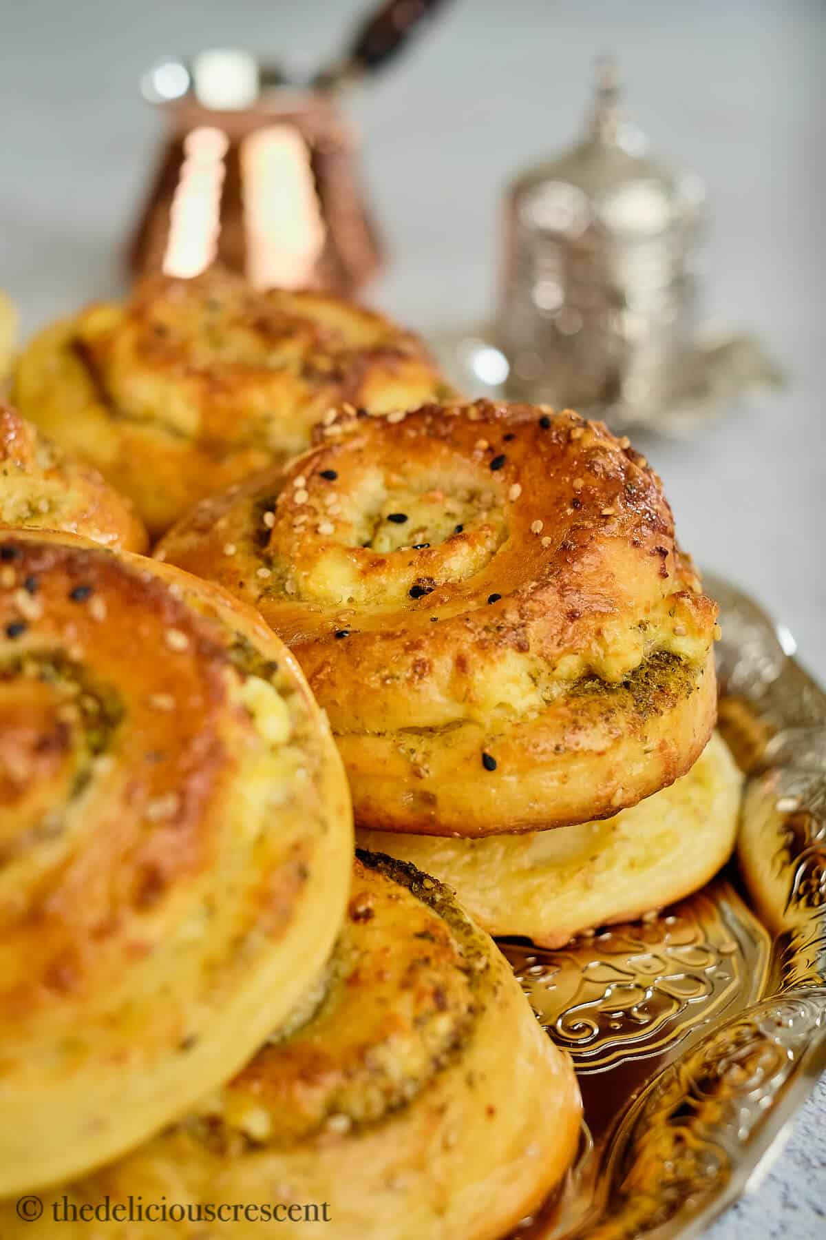 Bread rolls with cheese and zaatar served on a table.