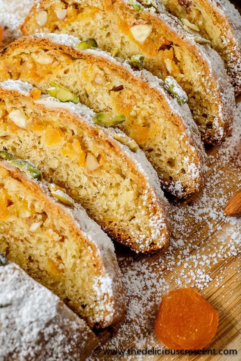 Marzipan stollen sliced and arranged on a wooden board.