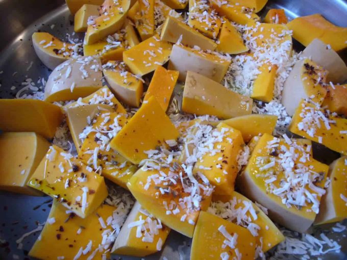 Butternut squash pieces topped with coconut flakes and spices.