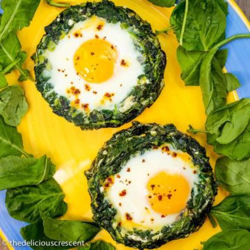 Portobello mushrooms stuffed with spinach, eggs and feta cheese, served on a plate.