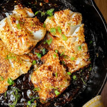 Pan seared fish with tamarind sauce served in a cast iron skillet.