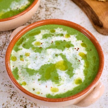 Close view of mustard greens soup served on the table.