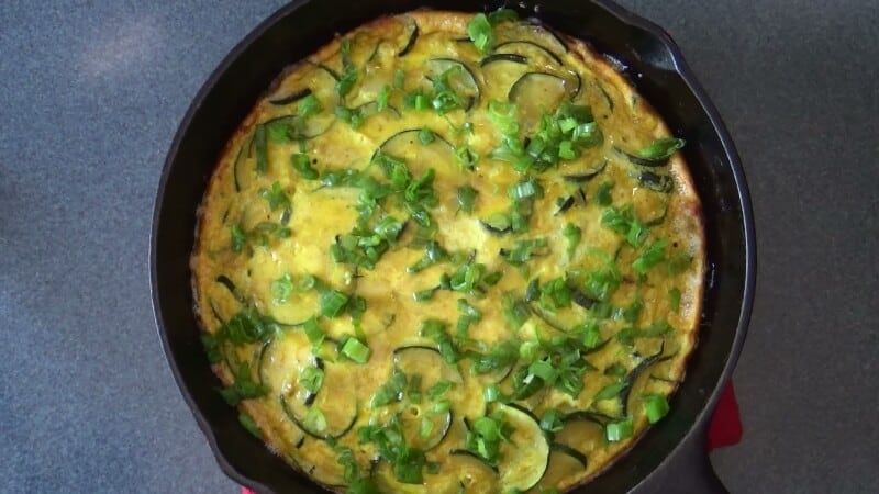 Chopped fresh herbs scattered on top of frittata.