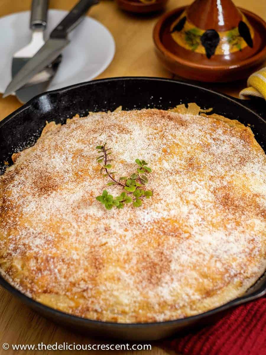 Closer view of Moroccan chicken pastilla baked in a cast iron skillet.