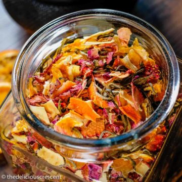 Homemade tea blend made with rose, citrus, berry, apple and stored in a glass bottle.