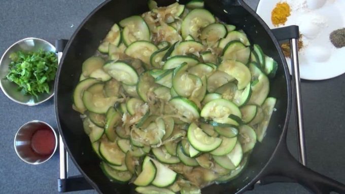 Zucchini being sauteed to prepare kuku kadoo.