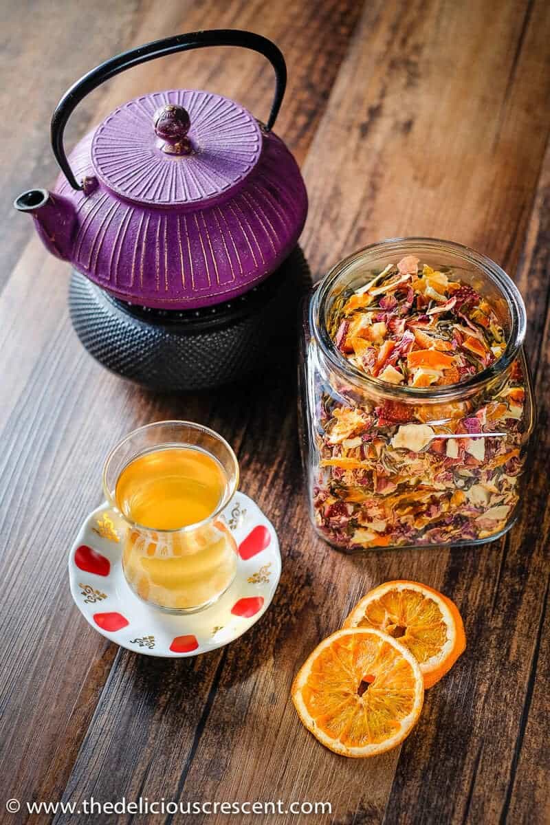 Homemade tea blend similar to a teavana tea blend placed in a glass jar along with the tea infusion.